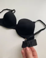 hand-is-holding-smooth-classic-black-bra-with-push-up-and-bow-C-cup-on-the-white-background