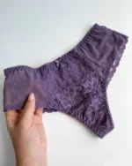 hand-is-holding-lilac-lace-brazilian-panties-with-mash