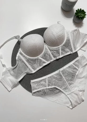 white-lace-set-of-a-bustier-bra-with-push-up-and-panties-with-belts-with-a-plant-and-candle-nearby