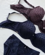 dark-purple-and-blue-polka-dot-sets-of-bras-and-panties-with-pieces-of-lace-and-bows-on-the-white-background