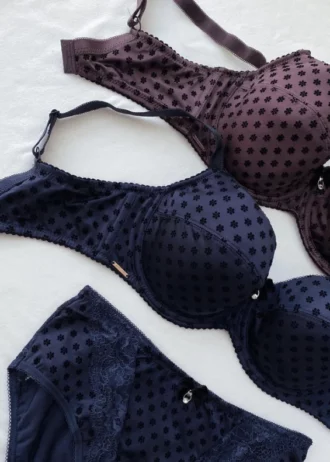 dark-purple-and-blue-polka-dot-sets-of-bras-and-panties-with-pieces-of-lace-and-bows-on-the-white-background