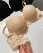 hand-is-holding-smooth-beige-and-black-classic-bras-with-lace-on-the-lower-part-with-thin-foam-C-cup