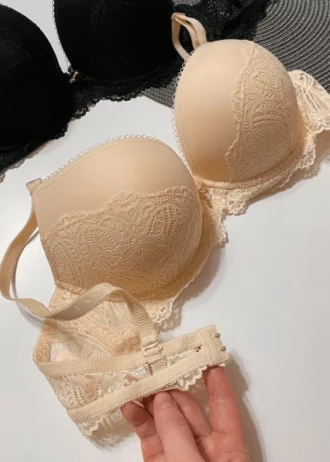 hand-is-holding-smooth-beige-and-black-classic-bras-with-lace-on-the-lower-part-with-thin-foam-C-cup