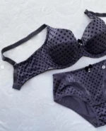 dark-purple-polka-dot-set-of-a-bra-and-panties-with-pieces-of-lace-and-bows-on-the-white-background