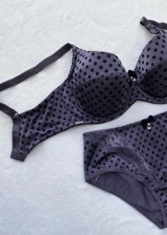 dark-purple-polka-dot-set-of-a-bra-and-panties-with-pieces-of-lace-and-bows-on-the-white-background