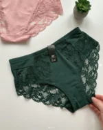 hand-is-holding-green-and-powdery-cotton-high-waisted-slips-with-pieces-of-lace